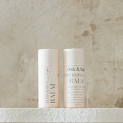 Oak & Sage Peppermint Lip Balm duo with eco-friendly paper tubes, featuring clean, natural ingredients like tallow, jojoba oil, peppermint, honey, and beeswax, styled against a neutral stone background.