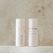 Oak & Sage Vanilla Lip Balm duo with eco-friendly paper tubes, featuring clean, natural ingredients like tallow, jojoba oil, vanilla, honey, and beeswax, styled against a neutral stone background.