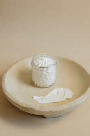 Oak & Sage whipped tallow Everywhere Cream in a glass jar, displayed on a natural stone dish with a textured butter-like swatch to highlight its rich, moisturizing consistency.