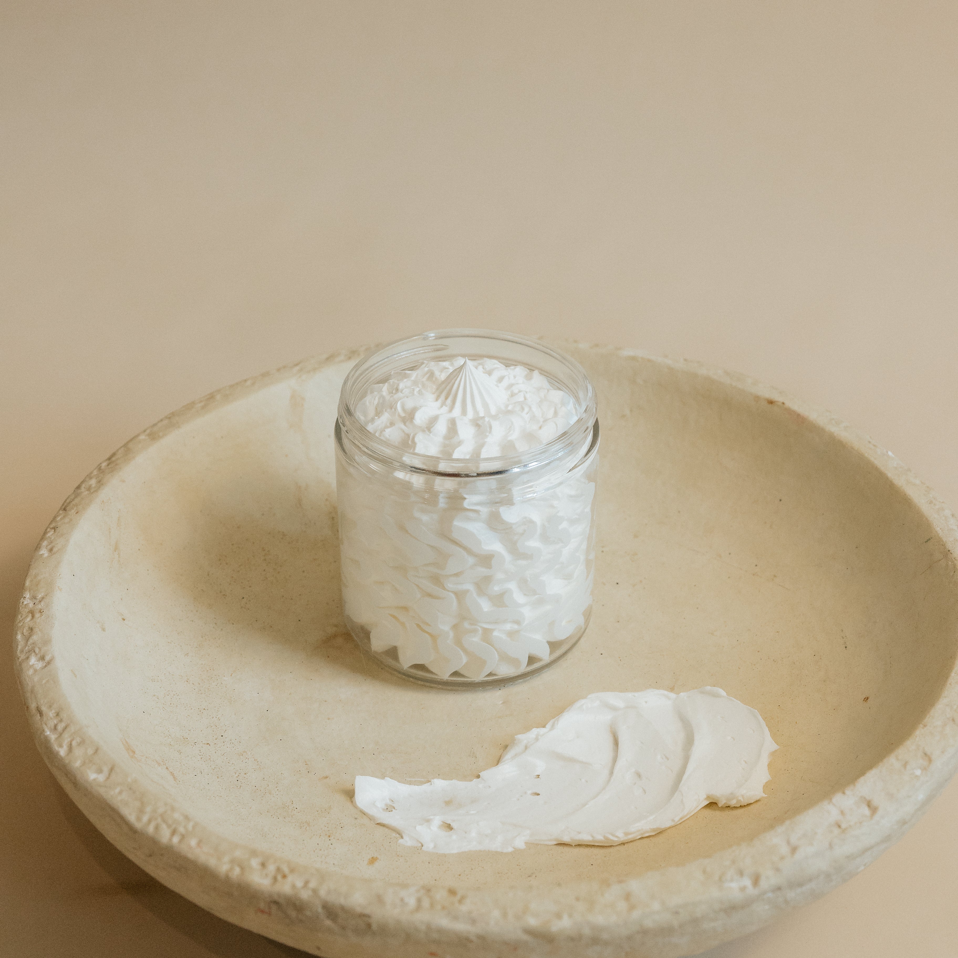 Oak & Sage whipped tallow Everywhere Cream in a glass jar, displayed on a natural stone dish with a textured butter-like swatch to highlight its rich, moisturizing consistency.
