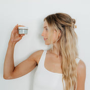 Woman holding Oak & Sage Cleansing Balm in glass jar – natural tallow-based face cleanser for removing makeup and nourishing skin barrier.